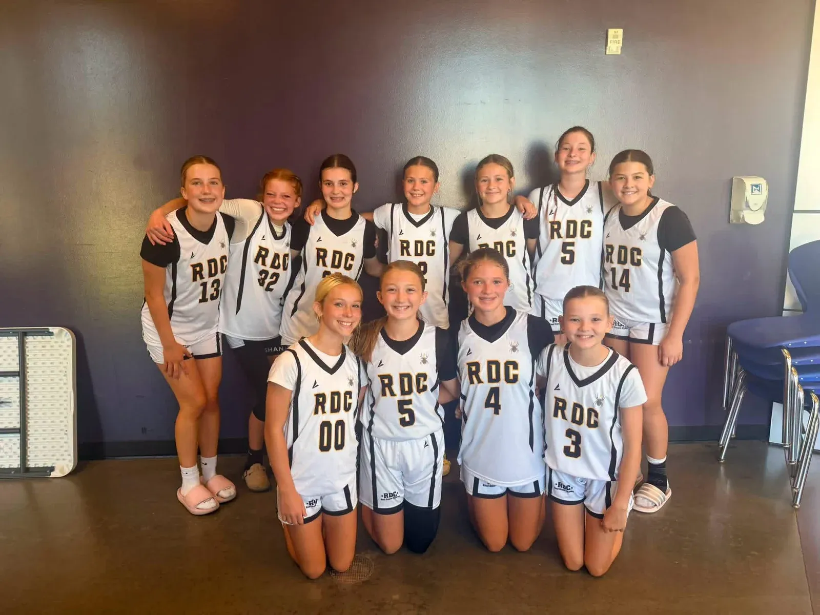 RDC basketball teammates gathered for a group photo in white uniforms