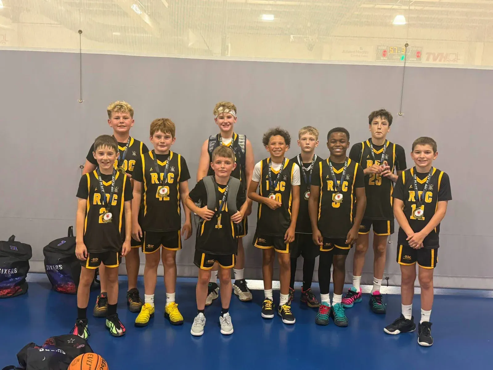 RDC basketball teammates in black and gold uniforms wearing medals